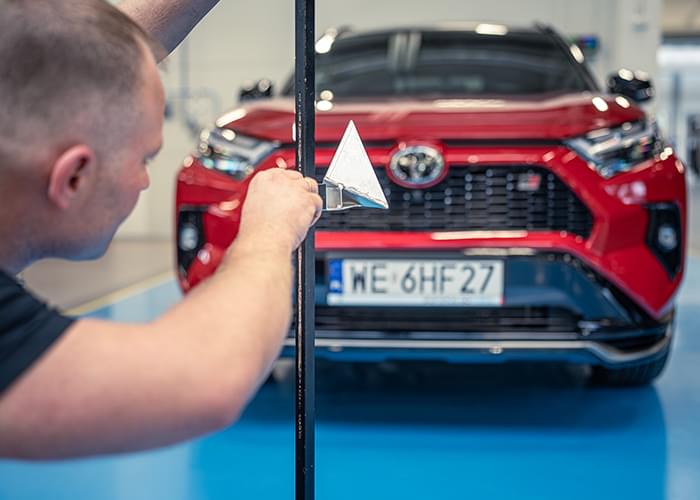 Mechanik sprawdza ustawienie świateł pojazdu