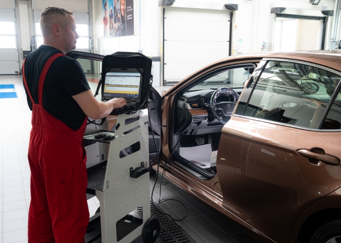 Mechanik wykonuje diagnostykę komputerową samochodu w warsztacie